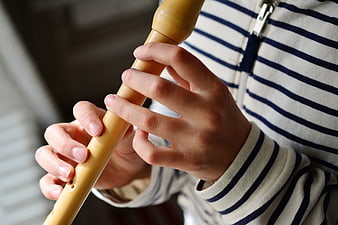 Close-up of child playing wooden recorder