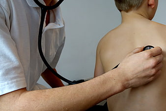 Doctor examining child's back with stethoscope