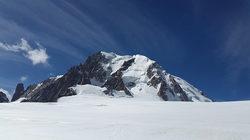 Snowy Mountain Peak Against Blue Sky with Clouds