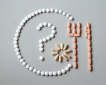 Pills arranged in copyright symbol and 411 on gray background