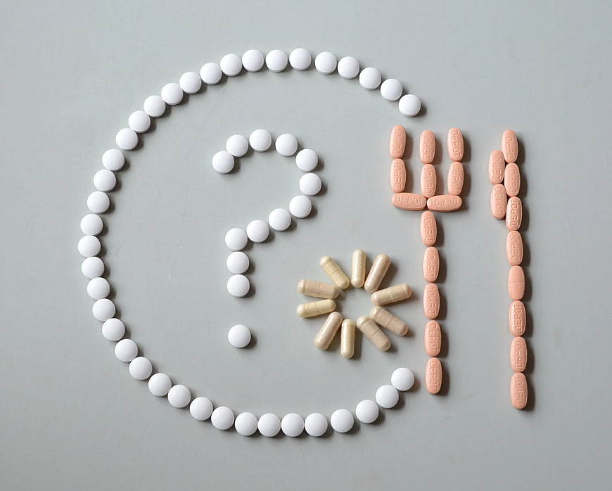 Pills arranged in copyright symbol and 411 on gray background