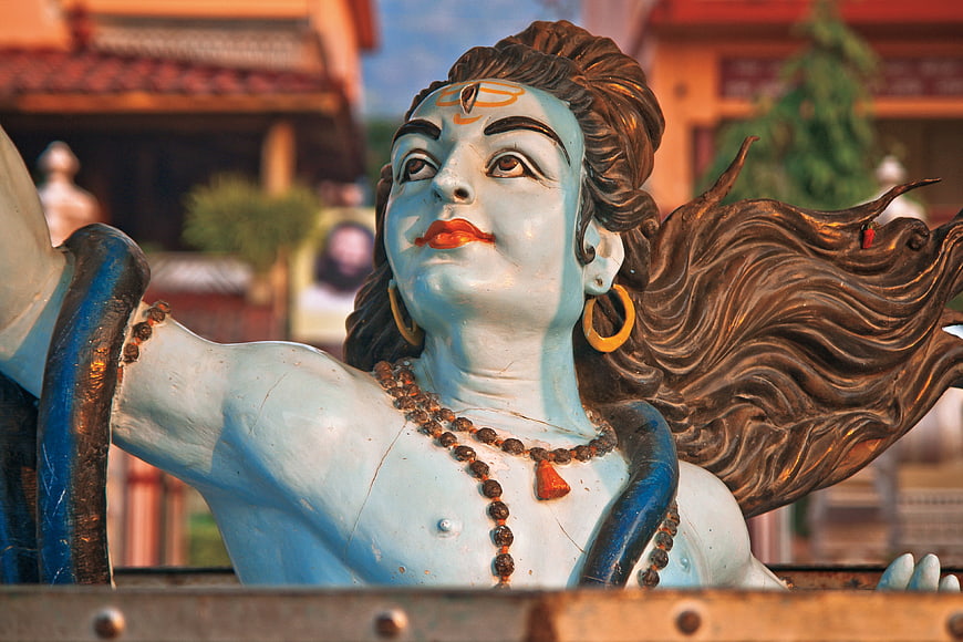 Close-up of a blue Hindu deity statue with flowing hair and beads