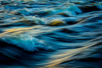 Abstract flowing water with blue and gold reflections