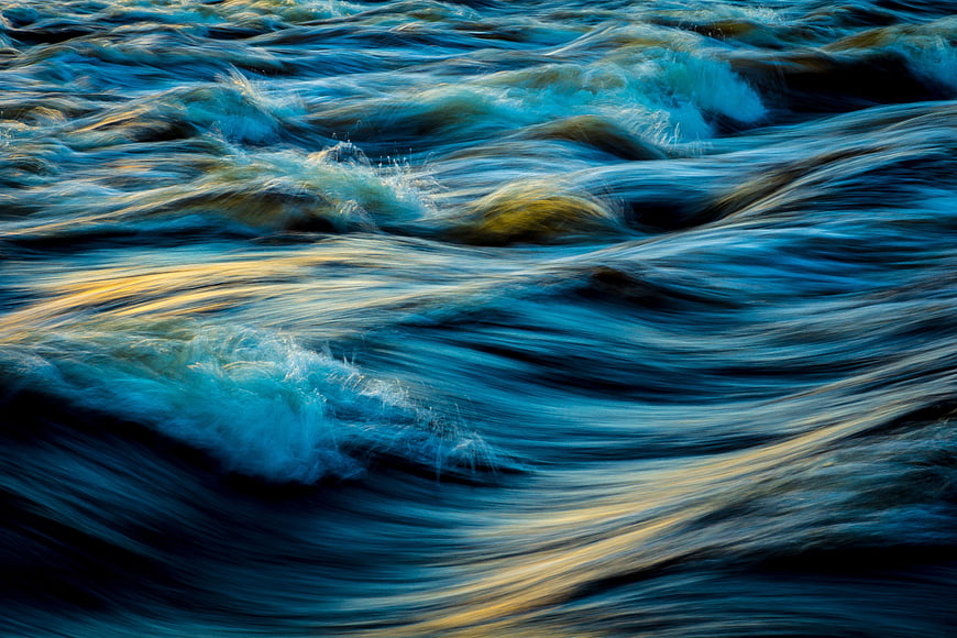 Abstract flowing water with blue and gold reflections