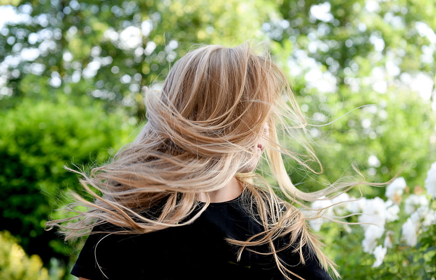 Blonde Woman with Windblown Hair in Garden