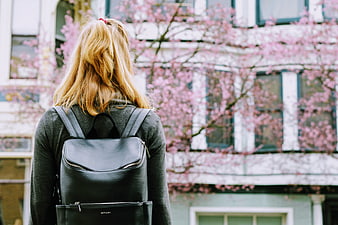 Woman with Black Backpack Facing Cherry Blossoms