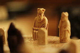 Close-up of carved wooden chess pieces on a patterned board