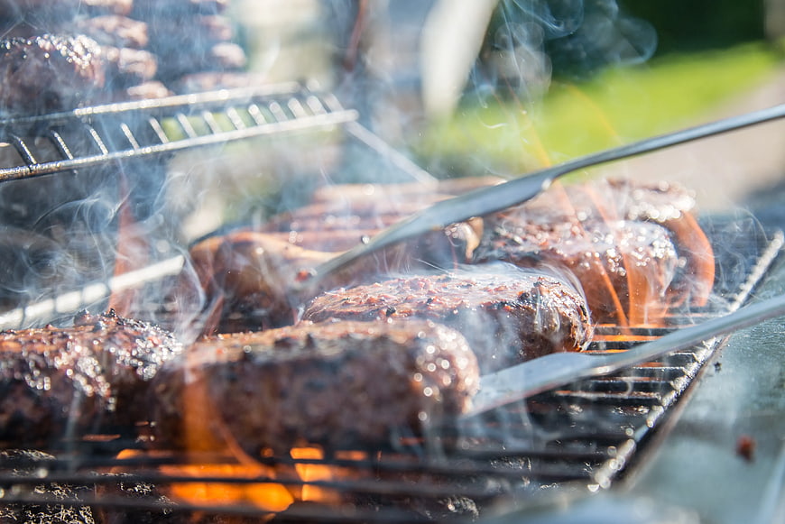 Close-up of Sizzling Burgers Grilling on Outdoor BBQ