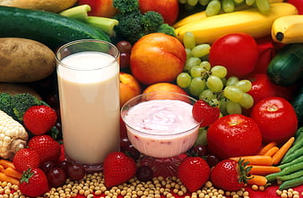 Glass of milk and yogurt surrounded by fresh fruits and vegetables