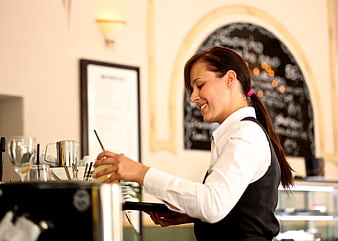 Smiling waitress preparing a drink in a cafe
