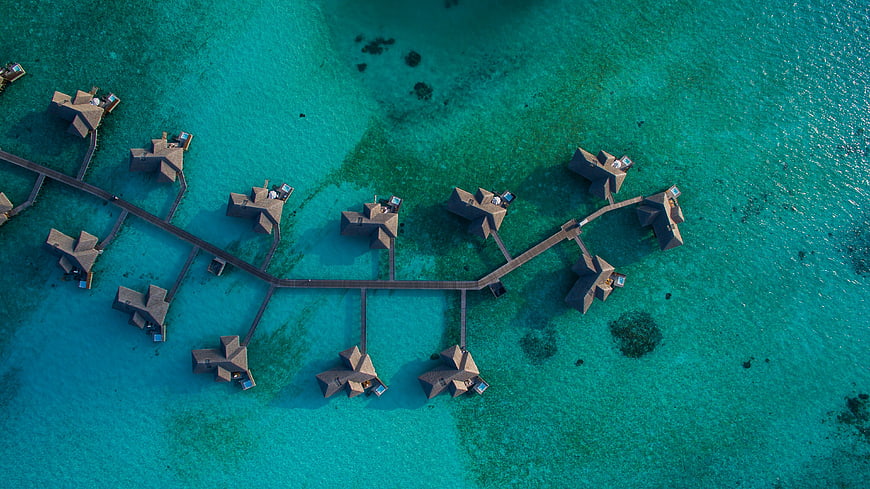 Aerial View of Overwater Bungalows in Turquoise Lagoon
