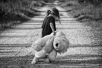 Little Girl Dragging Large Teddy Bear Down Rural Road