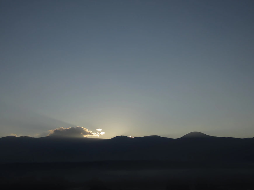 Silhouette of mountains at sunset with sun rays
