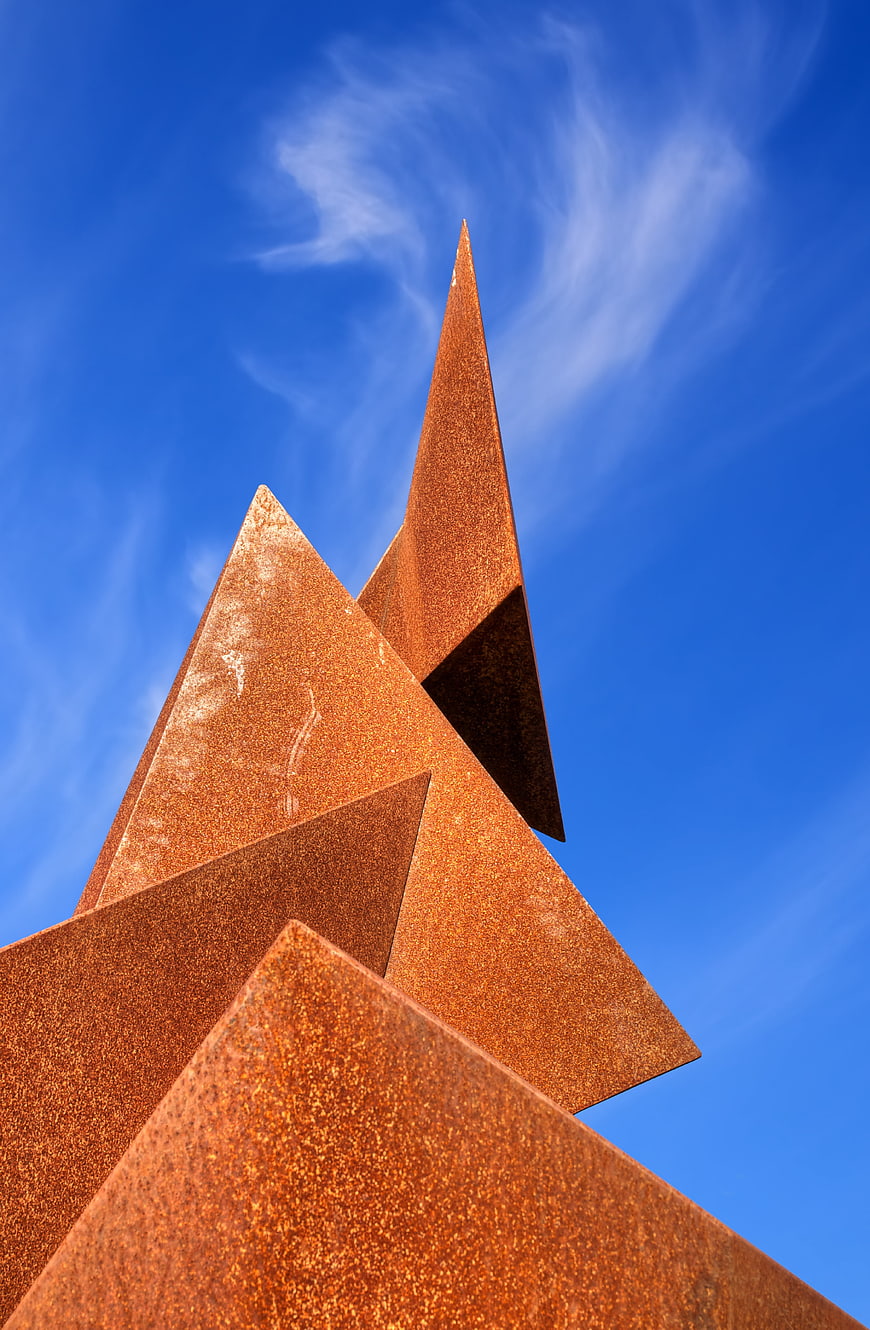 Rusty metal sculpture against blue sky