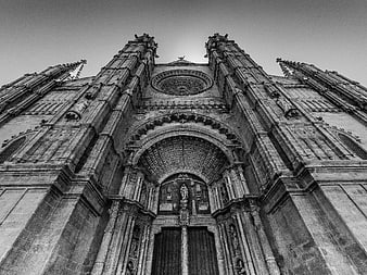 Low angle black and white photo of Gothic cathedral facade