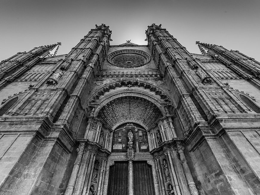 Low angle black and white photo of Gothic cathedral facade