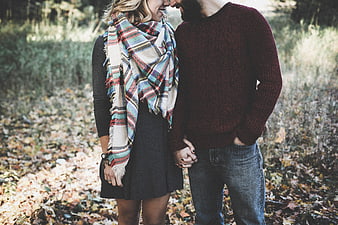Happy couple holding hands in autumn forest