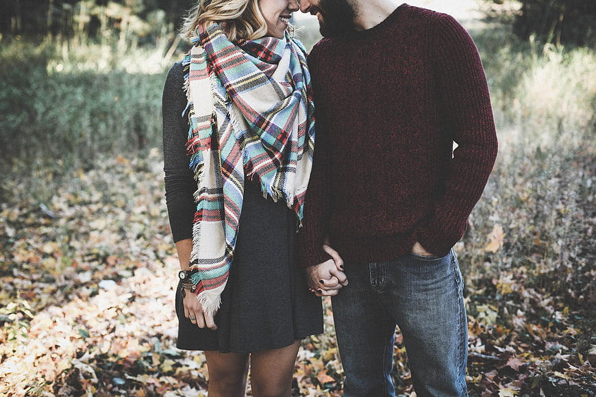Happy couple holding hands in autumn forest