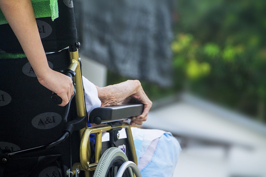Close-up of elderly person in wheelchair outdoors