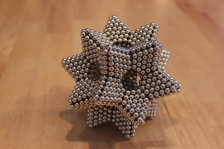 Magnetic Ball Star Sculpture On Wooden Surface