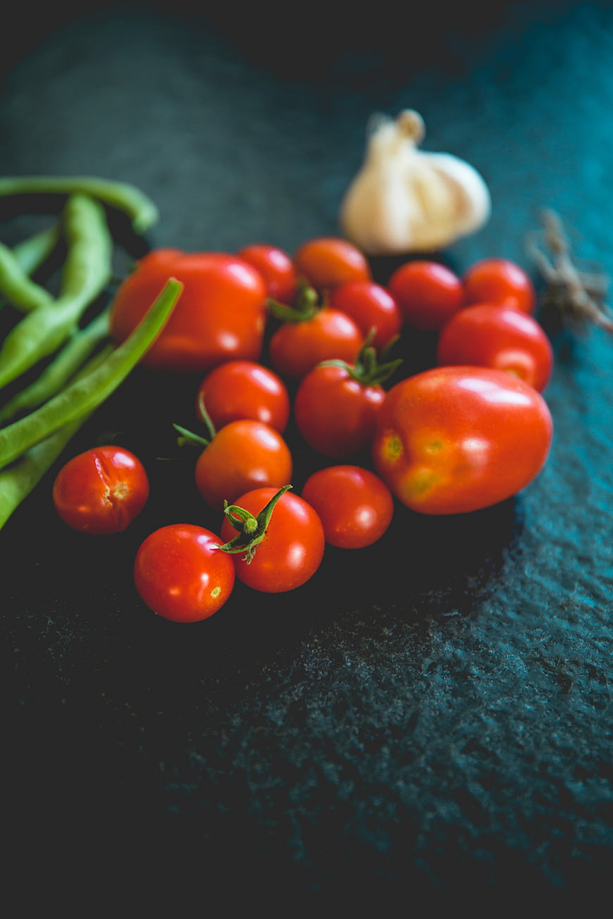 Fresh Tomatoes, Green Beans, and Garlic on Dark Textured Background