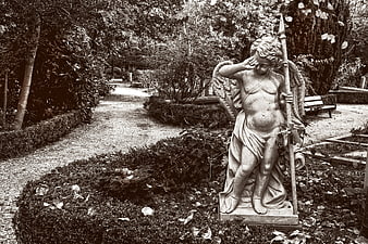 Sepia-toned angel statue in a garden cemetery