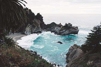 Scenic coastal cove with turquoise water and waterfall
