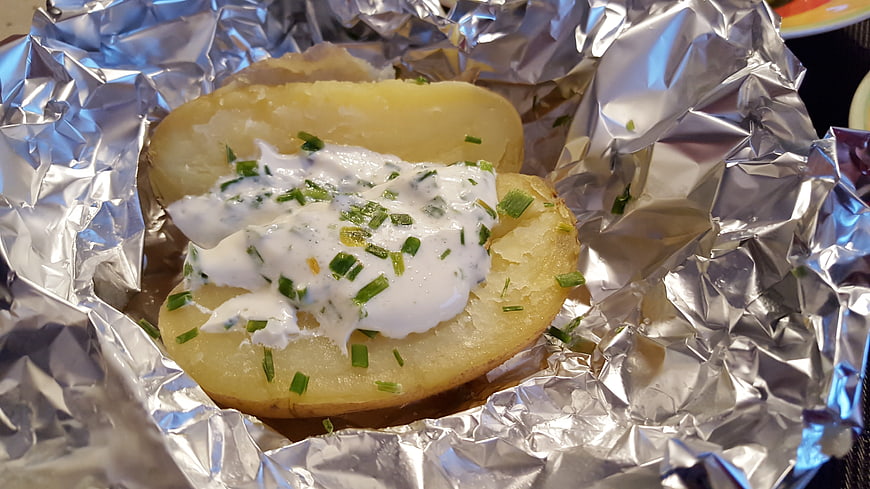 Baked Potato with Sour Cream and Chives in Aluminum Foil