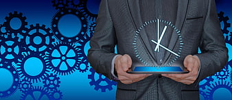 Businessman holding tablet with holographic clock and gears background
