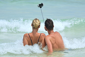 Couple Taking Selfie in Ocean Waves with Smartphone