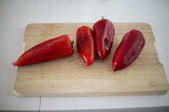 Fresh red peppers on wooden cutting board