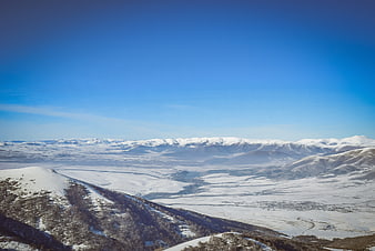 Panoramic winter landscape of snow-covered mountains and valley