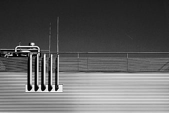 Black and white industrial pipes on corrugated metal wall