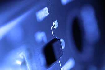 Close-up of audio equipment power switch in blue light
