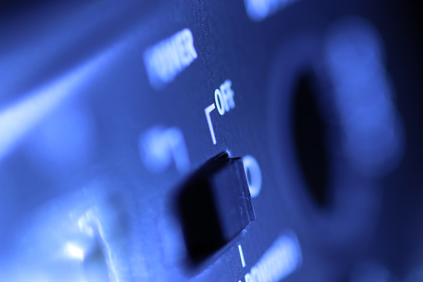 Close-up of audio equipment power switch in blue light