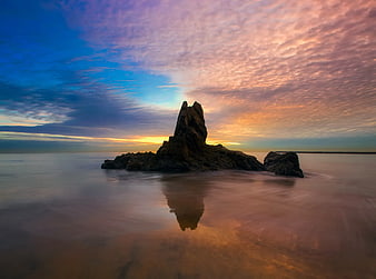 Dramatic Sunset Over Rocky Sea Stack with Long Exposure Reflection