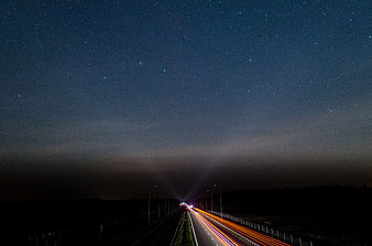 Long Exposure Night Highway with Starry Sky and Light Trails