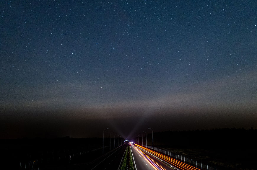 Long Exposure Night Highway with Starry Sky and Light Trails