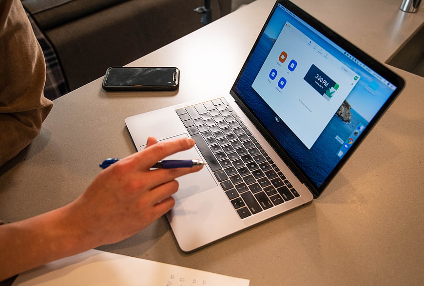 Person using laptop for virtual meeting on desk