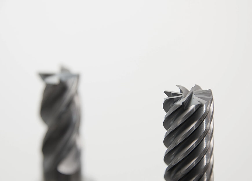 Close-up of metal drill bits on white background