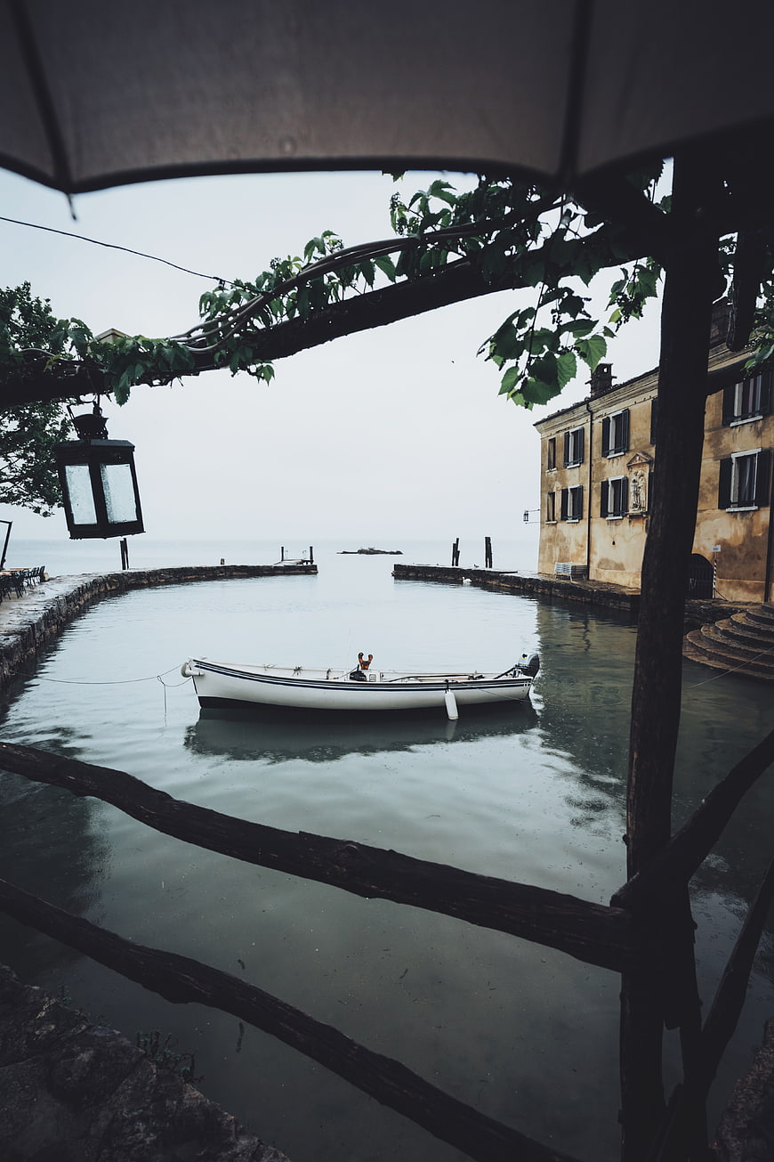 Serene white boat moored in calm canal under overcast sky