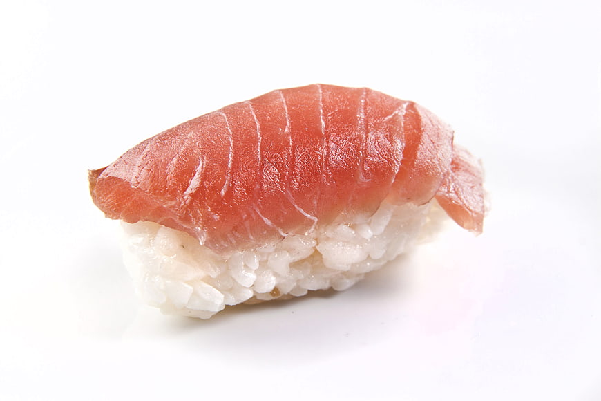 Single piece of salmon nigiri sushi on white background