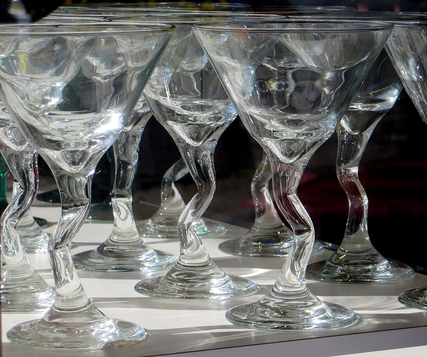 Twisted stem martini glasses on white surface