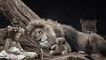 Little girl reading book with sleeping lion and teddy bear