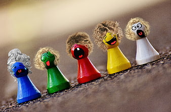 Colorful wooden peg dolls with painted faces and yarn hair