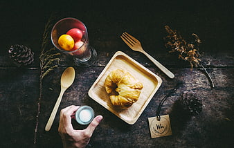 Top view of croissant breakfast with wooden cutlery and fruit