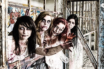 Group of female zombies reaching through rusty bars