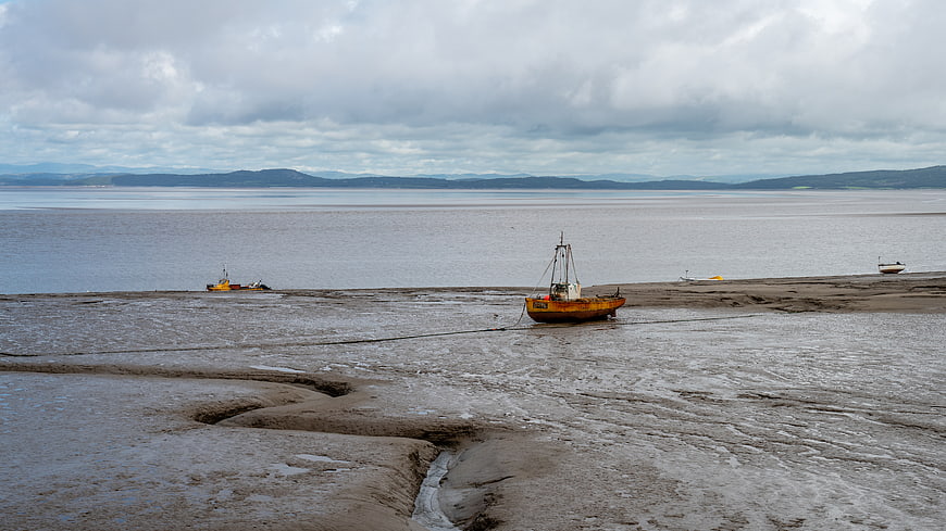 Yellow fishing boat stranded on muddy tidal flats