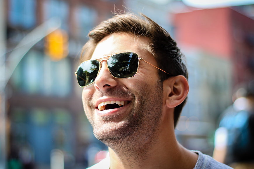 Happy Man Laughing with Sunglasses in Urban Setting