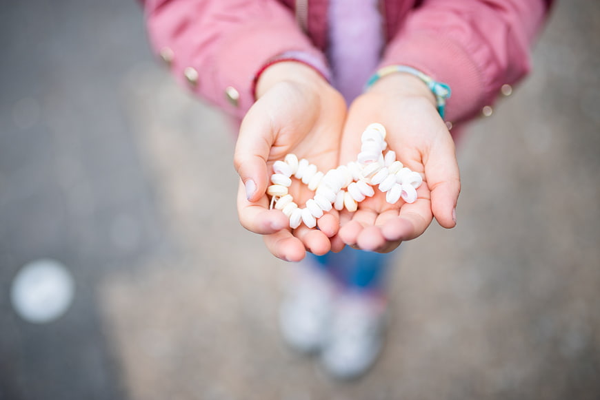 Child holding white spiral candies in cupped hands